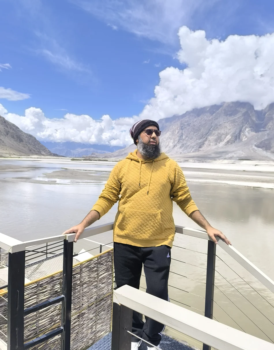 Muhammad Ahsan on a river deck below the mountains at Skardu, northern Pakistan