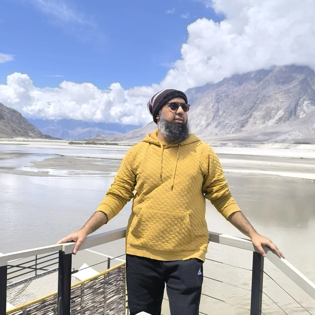 Muhammad Ahsan on a river deck below the mountains at Skardu, northern Pakistan