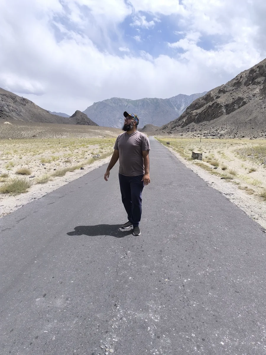 Muhammad Ahsan standing on an empty mountain road near Skardu, Pakistan